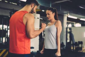 fitness coach motivating his client to get through a tough workout