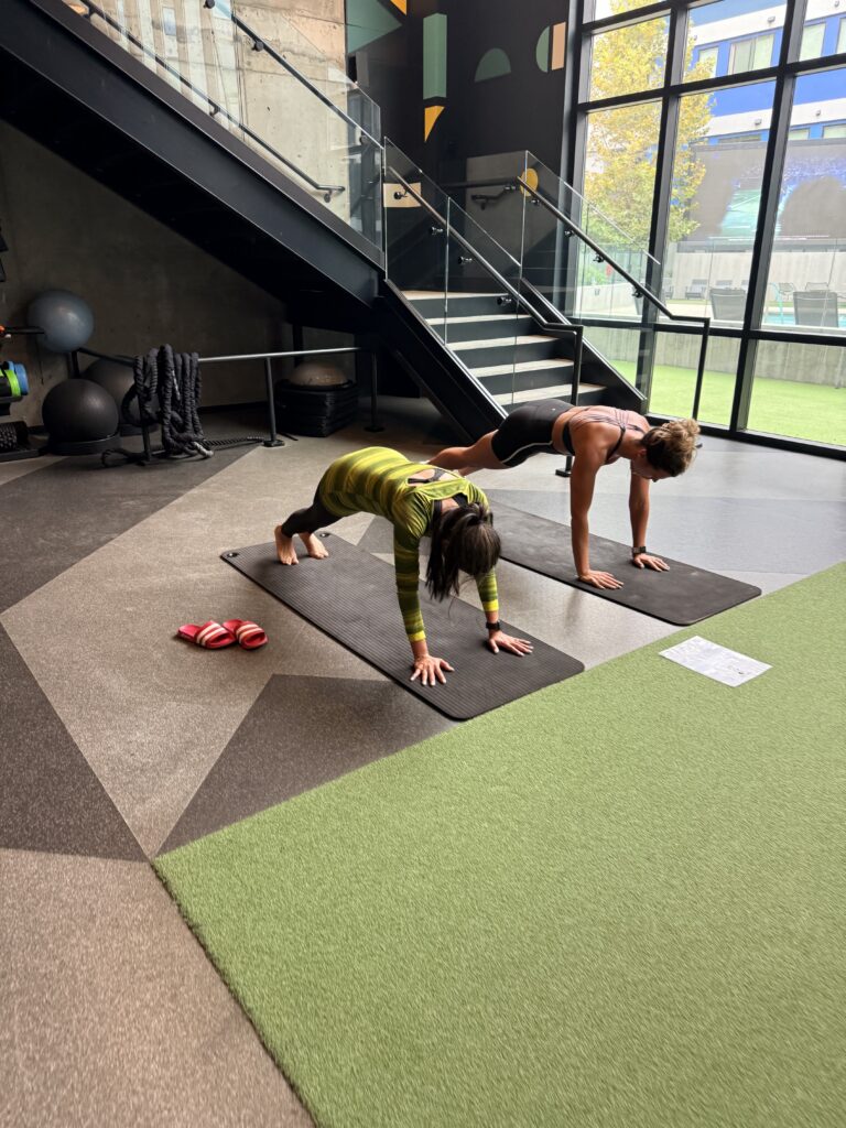 Two residents doing plank variations on mats